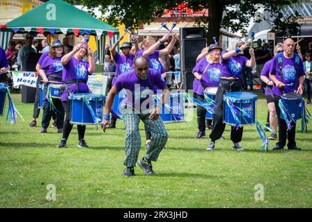 Danny Henry, artiste de danse noire, danse au rythme du groupe de tambours Batida Rio Samba lors de la Journée de sensibilisation au handicap 2023 à Warrington Banque D'Images