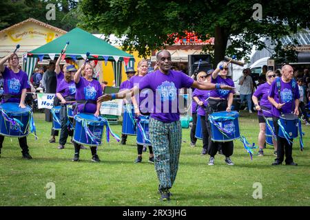 Danny Henry, artiste de danse noire, danse au rythme du groupe de tambours Batida Rio Samba lors de la Journée de sensibilisation au handicap 2023 à Warrington Banque D'Images