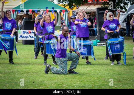 Danny Henry, artiste de danse noire, danse au rythme du groupe de tambours Batida Rio Samba lors de la Journée de sensibilisation au handicap 2023 à Warrington Banque D'Images