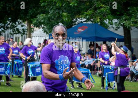 Danny Henry, artiste de danse noire, danse au rythme du groupe de tambours Batida Rio Samba lors de la Journée de sensibilisation au handicap 2023 à Warrington Banque D'Images