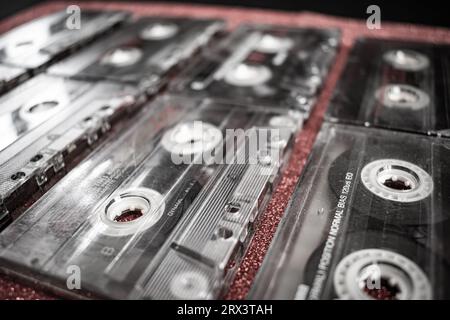 Gros plan d'un ensemble de cassettes audio rétro vintage sur fond rouge. Banque D'Images