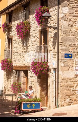 Femme pèlerin se reposant pour lire un guide tout en marchant le Camino de Santiago le chemin de Saint James route de pèlerinage dans la ville espagnole de Belorado Banque D'Images