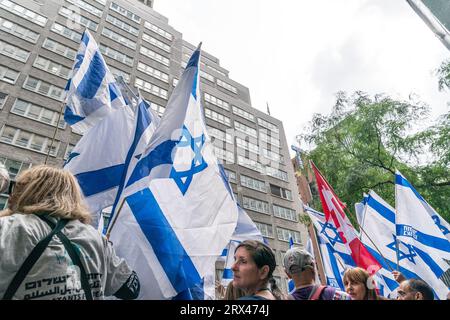 New York, États-Unis. 22 septembre 2023. Des centaines de militants se rassemblent contre les réformes judiciaires proposées par le gouvernement devant la mission israélienne auprès de l’ONU sur la 2e Avenue à New York alors que le Premier ministre Benjamin Netanyahu se rend le 22 septembre 2023. Le rassemblement a eu lieu après le discours prononcé par le Premier ministre lors de la 78e session de l'Assemblée générale des Nations Unies. Drapeau israélien au sommet de la mission vu à travers les manifestants. (Photo de Lev Radin/Sipa USA) crédit : SIPA USA/Alamy Live News Banque D'Images