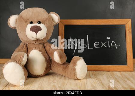 Ours en peluche et petit tableau noir avec mot Dyslexia sur la table en bois Banque D'Images