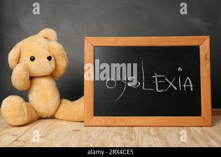 Ours en peluche et petit tableau noir avec mot Dyslexia sur la table en bois Banque D'Images