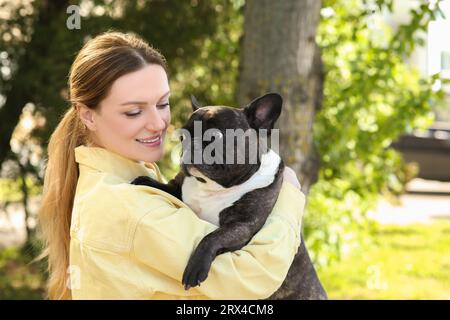 Femme heureuse avec mignon Bulldog français à l'extérieur Banque D'Images