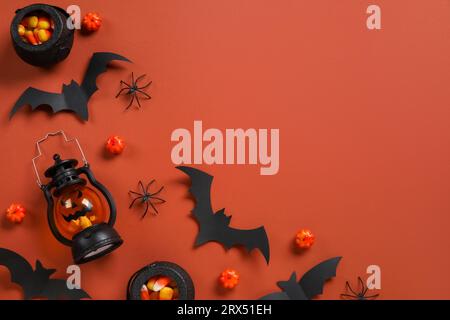 Composition avec des cors de bonbons savoureux, lanterne et décor d'Halloween sur fond brun Banque D'Images
