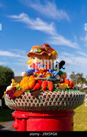 Poole, Dorset, Royaume-Uni. 23 septembre 2023. UK Météo : Sunshine comme un topper de boîte aux lettres crocheté tricoté apparaît sur une boîte aux lettres rouge à Poole, Dorset avec un thème du Festival de la récolte, une célébration de la récolte et de la nourriture cultivée, pour célébrer quand les cultures ont été rassemblées et les gens peuvent réfléchir et montrer de la gratitude pour la nourriture qu'ils ont. Crédit : Carolyn Jenkins/Alamy Live News Banque D'Images