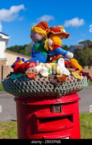 Poole, Dorset, Royaume-Uni. 23 septembre 2023. UK Météo : Sunshine comme un topper de boîte aux lettres crocheté tricoté apparaît sur une boîte aux lettres rouge à Poole, Dorset avec un thème du Festival de la récolte, une célébration de la récolte et de la nourriture cultivée, pour célébrer quand les cultures ont été rassemblées et les gens peuvent réfléchir et montrer de la gratitude pour la nourriture qu'ils ont. Crédit : Carolyn Jenkins/Alamy Live News Banque D'Images