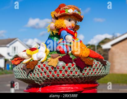 Poole, Dorset, Royaume-Uni. 23 septembre 2023. UK Météo : Sunshine comme un topper de boîte aux lettres crocheté tricoté apparaît sur une boîte aux lettres rouge à Poole, Dorset avec un thème du Festival de la récolte, une célébration de la récolte et de la nourriture cultivée, pour célébrer quand les cultures ont été rassemblées et les gens peuvent réfléchir et montrer de la gratitude pour la nourriture qu'ils ont. Crédit : Carolyn Jenkins/Alamy Live News Banque D'Images