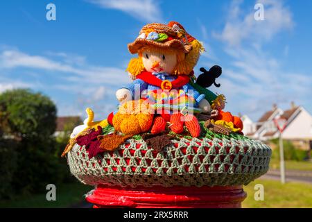 Poole, Dorset, Royaume-Uni. 23 septembre 2023. UK Météo : Sunshine comme un topper de boîte aux lettres crocheté tricoté apparaît sur une boîte aux lettres rouge à Poole, Dorset avec un thème du Festival de la récolte, une célébration de la récolte et de la nourriture cultivée, pour célébrer quand les cultures ont été rassemblées et les gens peuvent réfléchir et montrer de la gratitude pour la nourriture qu'ils ont. Crédit : Carolyn Jenkins/Alamy Live News Banque D'Images