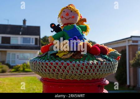 Poole, Dorset, Royaume-Uni. 23 septembre 2023. UK Météo : Sunshine comme un topper de boîte aux lettres crocheté tricoté apparaît sur une boîte aux lettres rouge à Poole, Dorset avec un thème du Festival de la récolte, une célébration de la récolte et de la nourriture cultivée, pour célébrer quand les cultures ont été rassemblées et les gens peuvent réfléchir et montrer de la gratitude pour la nourriture qu'ils ont. Crédit : Carolyn Jenkins/Alamy Live News Banque D'Images