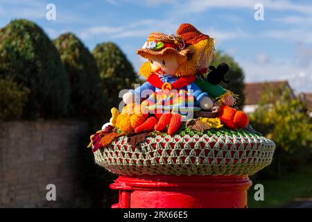 Poole, Dorset, Royaume-Uni. 23 septembre 2023. UK Météo : Sunshine comme un topper de boîte aux lettres crocheté tricoté apparaît sur une boîte aux lettres rouge à Poole, Dorset avec un thème du Festival de la récolte, une célébration de la récolte et de la nourriture cultivée, pour célébrer quand les cultures ont été rassemblées et les gens peuvent réfléchir et montrer de la gratitude pour la nourriture qu'ils ont. Crédit : Carolyn Jenkins/Alamy Live News Banque D'Images