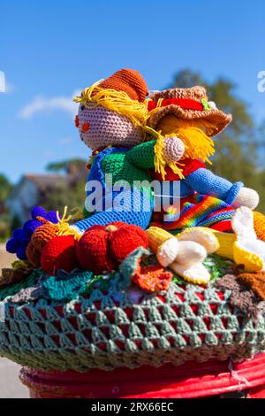 Poole, Dorset, Royaume-Uni. 23 septembre 2023. UK Météo : Sunshine comme un topper de boîte aux lettres crocheté tricoté apparaît sur une boîte aux lettres rouge à Poole, Dorset avec un thème du Festival de la récolte, une célébration de la récolte et de la nourriture cultivée, pour célébrer quand les cultures ont été rassemblées et les gens peuvent réfléchir et montrer de la gratitude pour la nourriture qu'ils ont. Crédit : Carolyn Jenkins/Alamy Live News Banque D'Images