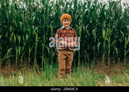 Heureux garçon debout devant les cultures de maïs Banque D'Images Heureux garçon debout devant les cultures de maïs Banque D'Images