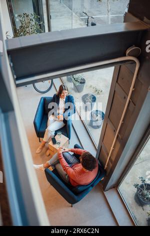 Smiling businessman and businesswoman talking in office Banque D'Images