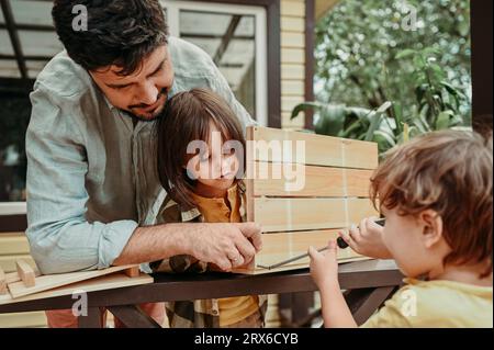 Père et fils préparant la caisse en bois dans la cour arrière Banque D'Images