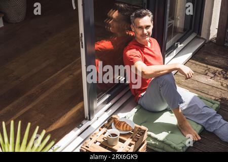 Portrait d'homme se détendant sur le balcon Banque D'Images