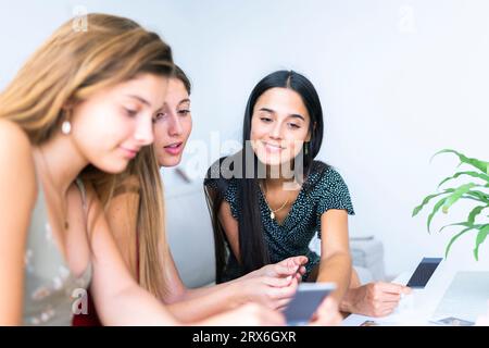 Amis souriants regardant des photos Banque D'Images