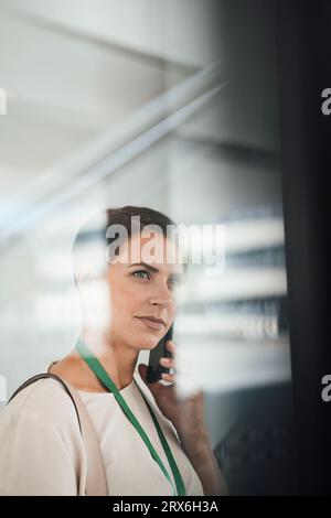 Femme d'affaires parlant sur le téléphone portable dans le lieu de travail Banque D'Images