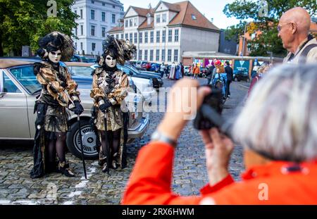 Schwerin, Allemagne. 23 septembre 2023. Avec des costumes colorés et des masques et chapeaux élaborés, environ 300 porteurs de costumes et de masques sont en mouvement à l'époque vénitienne dans la capitale de l'État. Une touche du carnaval vénitien amène les fans de costumes de toute l'Europe autour du château de Schwerin. En plus des visites de la ville, de l'agitation du marché, des concerts et des lectures de livres, des promenades en gondole font également partie du programme. Crédit : Jens Büttner/dpa/Alamy Live News Banque D'Images