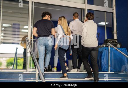 Vue arrière d'étudiants entrant à l'université pour des classes A. Ils ont une conversation Banque D'Images