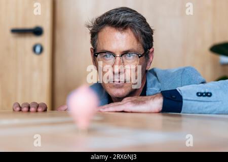 Homme d'affaires regardant la toupie au bureau Banque D'Images