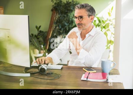 Freelance travaillant sur l'ordinateur au bureau dans le bureau à domicile Banque D'Images