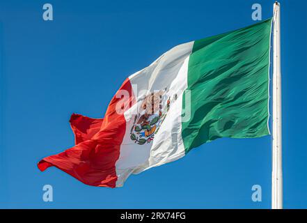 San Jose del Cabo Centro, Mexique - 16 juillet 2023 : gros plan du drapeau lui-même posé contre le ciel bleu du drapeau national mexicain Banque D'Images