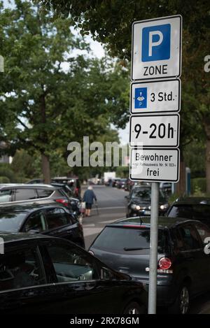 La zone de stationnement indique « parking des résidents » devant les routes bloquées près de l'aéroport de Hambourg. Vieille femme marchant sur la chaussée avec une canne. Banque D'Images