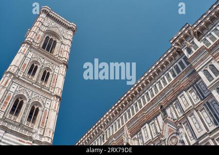 Vue de bas en haut du Campanile de Giotto avec ciel bleu, détail à droite de la cathédrale Santa Maria del Fiore à Florence Banque D'Images