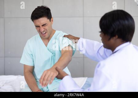 Patient sport masculin rencontre physiothérapeute médecin pour la douleur articulaire musculaire récupération physiothérapeute dans la clinique hospitalière Banque D'Images