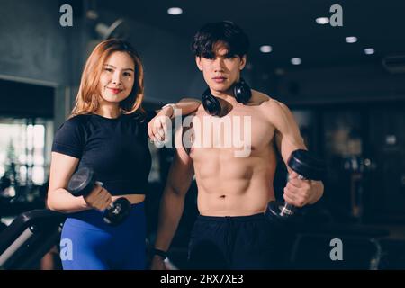 Portrait heureux sport homme et femme culturisme publicitaire athlète modèle entraînement musculaire dans le club de sport de gym de fitness Banque D'Images