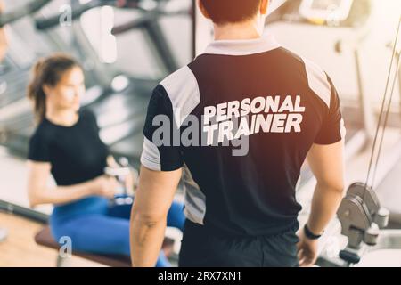 Entraîneur personnel dans Sport Club Fitness Gym pour assistant de programme de classe de culturisme Banque D'Images