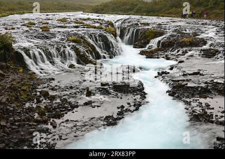 Touristes éloignés à Bruarfoss - Pont Falls - sur la route du cercle d'Or de l'Islande sous le ciel nuageux d'automne. Banque D'Images