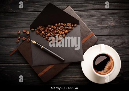 Grains de café sur une enveloppe en papier kraft. Fond noir. Photo de haute qualité Banque D'Images