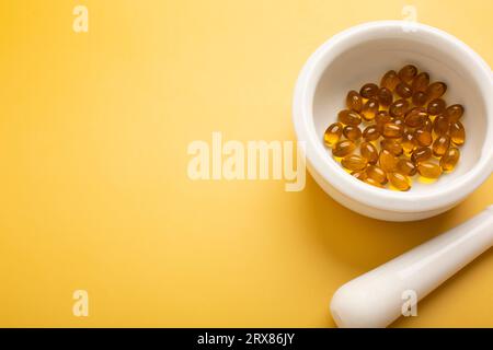 Vitamines ou pilules dans des récipients sur fond jaune. Placer pour le texte. Photo de haute qualité Banque D'Images