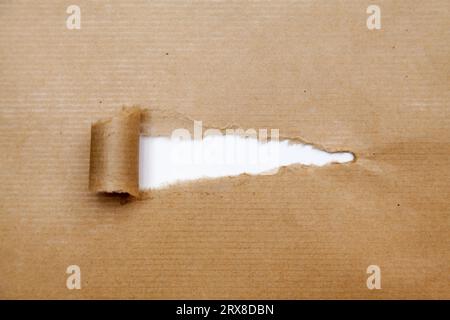 Papier brun déchiré révélant derrière un papier blanc avec espace de copie. Banque D'Images