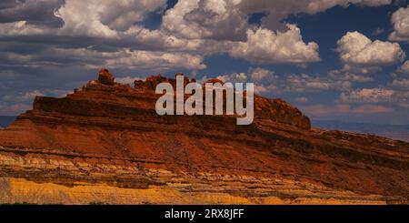 Des cumulus de rêve flottent au-dessus de Spotted Wolf Canyon dans le célèbre pays de roches rouges de l'Utah dans la houle de San Rafael par une journée d'été idyllique. Banque D'Images