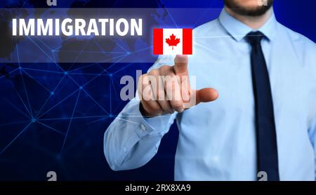 Immigration. Homme d'affaires touchant l'écran numérique avec le mot et le drapeau du Canada sur fond bleu foncé, closeup Banque D'Images