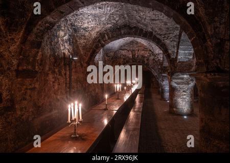 Trèves, Allemagne. 19 septembre 2023. Tables et bancs en bois pour les dégustations se trouvent dans la cave à vin de la cave de la fondation Vereinigte Hospitien à Trèves. L'ancien grenier romain de l'empereur Constantin de l'époque vers 330 est considéré comme l'origine de la plus ancienne cave à vin d'Allemagne. (To dpa text) crédit : Harald Tittel/dpa/Alamy Live News Banque D'Images