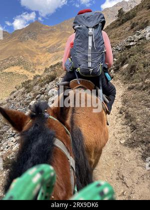 Vue arrière d'une femme à cheval sur le chemin du lac Humantay au Pérou Banque D'Images