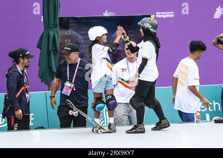 (230924) --HANGZHOU, 24 septembre 2023 (Xinhua) -- Mazel Paris Alegado (L, avant) des Philippines et Nyimas Bunga Cinta d'Indonésie célèbrent lors de la manche de skateboard de qualification des parcs féminins aux 19e Jeux asiatiques à Hangzhou, dans la province du Zhejiang, dans l'est de la Chine, le 24 septembre 2023. (Xinhua/Pan Yulong) Banque D'Images