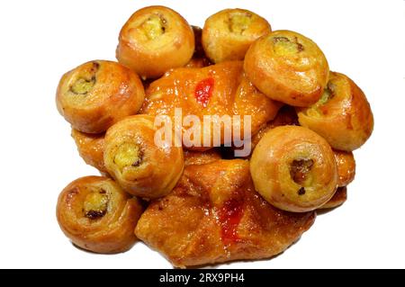 Fond de mini pâtisserie danoise farcie et garnie de sirop sucré au miel et de cerise et mini rouleau de bouffée tourbillon à la cannelle sucré avec ho Banque D'Images