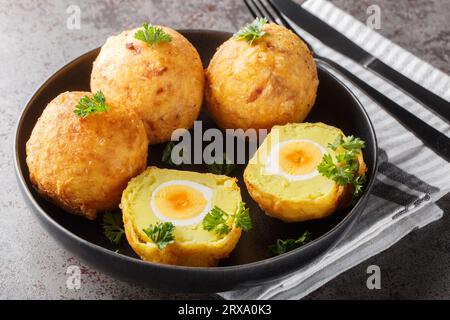 Boulettes de manioc guyanaises farcies d'œuf à la coque puis frites de près dans une assiette sur la table. Horizontal Banque D'Images