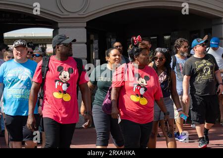 Orlando, États-Unis - 25 juillet 2023 : un couple de touristes avec des t-shirts Mickey Mouse assortis entrent dans Disney's Magic Kingdom. Banque D'Images