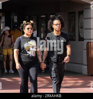 Orlando, États-Unis - 25 juillet 2023 : un couple de touristes avec des bandeaux adaptés à leur visite, entrent dans Disney's Magic Kingdom. Banque D'Images