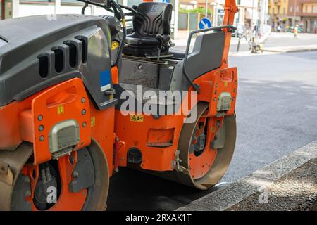 Orange tracteur avec cylindre pour revêtement en asphalte sur route Banque D'Images