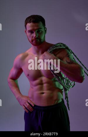 sérieux beau bodybuilder en sueur fatigué a le repos après l'entraînement, regarde la caméra. fond bleu isolé, bien-être, alpinisme, musculation, p Banque D'Images