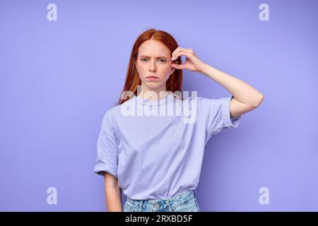 déprimé en colère gingembre sourd fille muette disant non, pas avec la main, gros plan portrait isolé fond bleu Banque D'Images